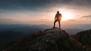 A person on top of a mountain representing an organization that is CMMC Ready.